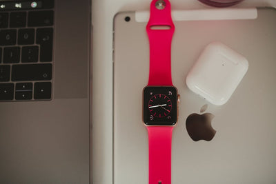 Close-up of a smartwatch, laptop, and earbuds showcasing sleek modern technology.