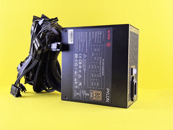 Black PC power supply unit with cables on a vibrant yellow backdrop. Ideal tech image.