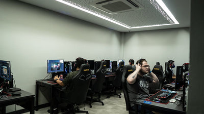 Group of gamers intensely playing video games in a modern esports center.