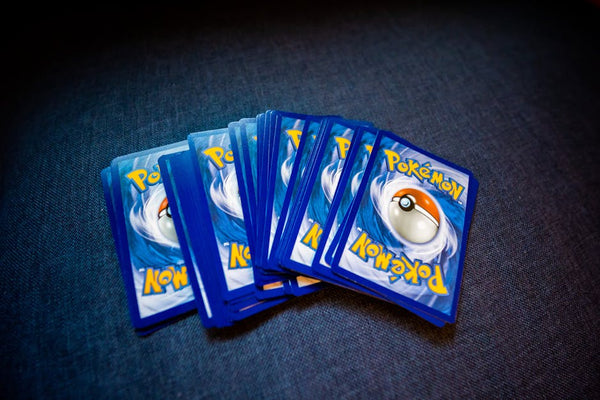 High angle of set of trading cards with images of fictional creatures placed against gray background