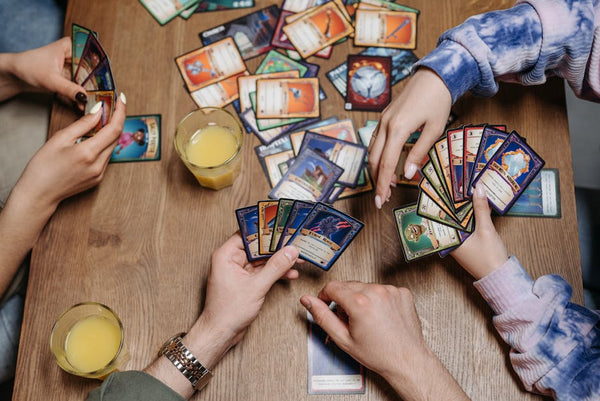 Close-up of friends playing a card game at a table, fostering socialization and togetherness.