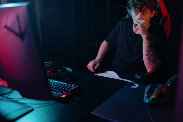 Young man intensely focused on a gaming session at night, highlighting the competitive esports atmosphere.