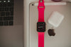 Close-up of a smartwatch, laptop, and earbuds showcasing sleek modern technology.