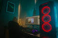 Atmospheric photo of a gaming setup with a glowing PC case and monitor displaying content editing software.