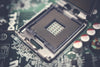 Detailed view of a CPU socket on a circuit board, highlighting electronic components.