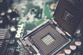Detailed view of a CPU socket on a green motherboard, showcasing microprocessor technology.