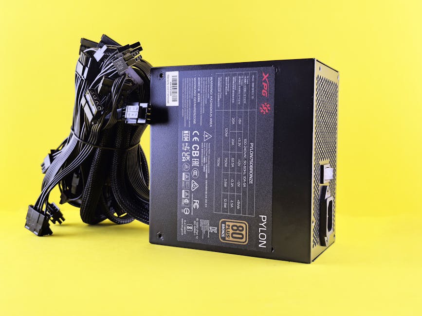 Black PC power supply unit with cables on a vibrant yellow backdrop. Ideal tech image.