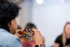 A person intently holds a variety of colorful game cards during indoor gathering.