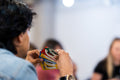A person intently holds a variety of colorful game cards during indoor gathering.