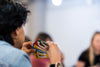 A person intently holds a variety of colorful game cards during indoor gathering.