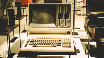 Old-fashioned General computer on display with a vintage keyboard and disk slots.