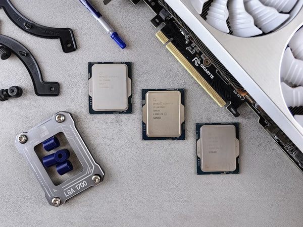 Overhead view of CPUs, graphics card, and mounting equipment on gray background, emphasizing modern technology.