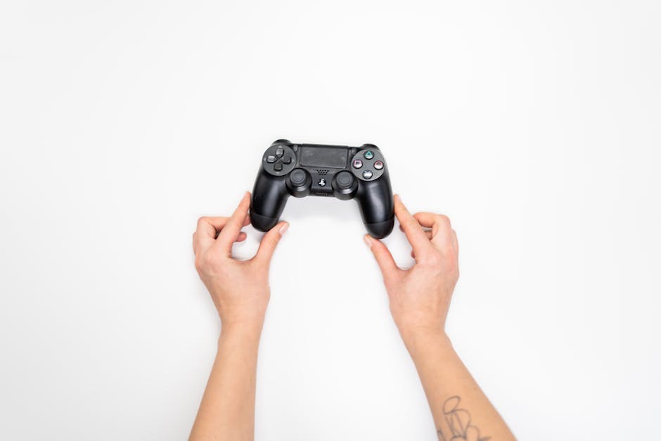 Top view of hands holding a black gaming controller against a white background.