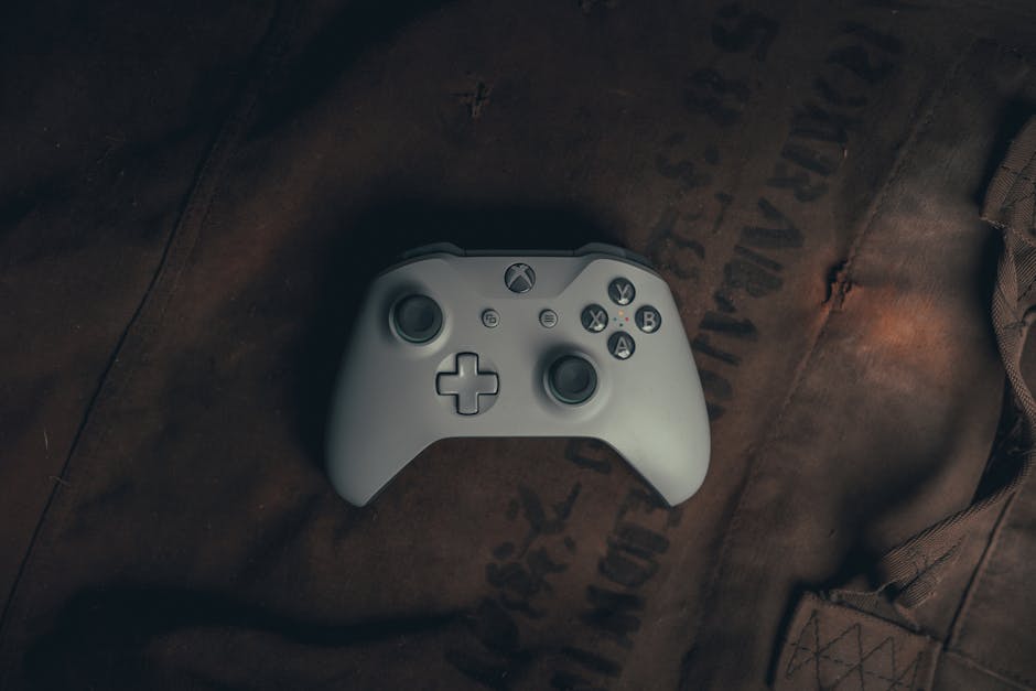 Top view of a gaming controller on rustic fabric, evoking a vintage gaming vibe.