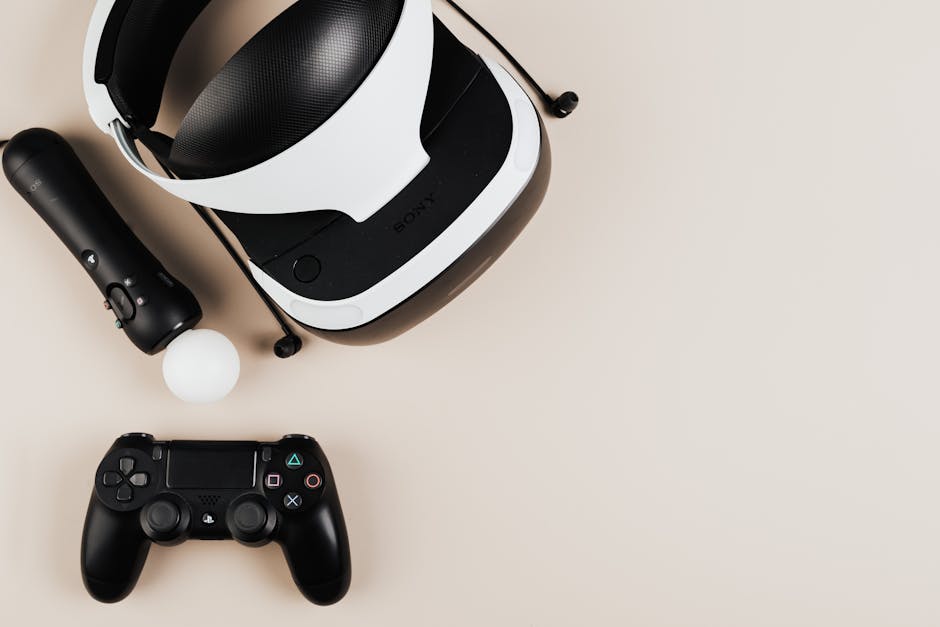 High-angle view of gaming controllers and VR headset on beige surface, showcasing modern technology.