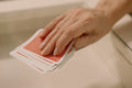 Hand selecting cards from deck on glass table reflects playful and recreational theme.