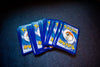 High angle of set of trading cards with images of fictional creatures placed against gray background