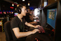 Group of men gaming in an internet cafe, focused on computers.