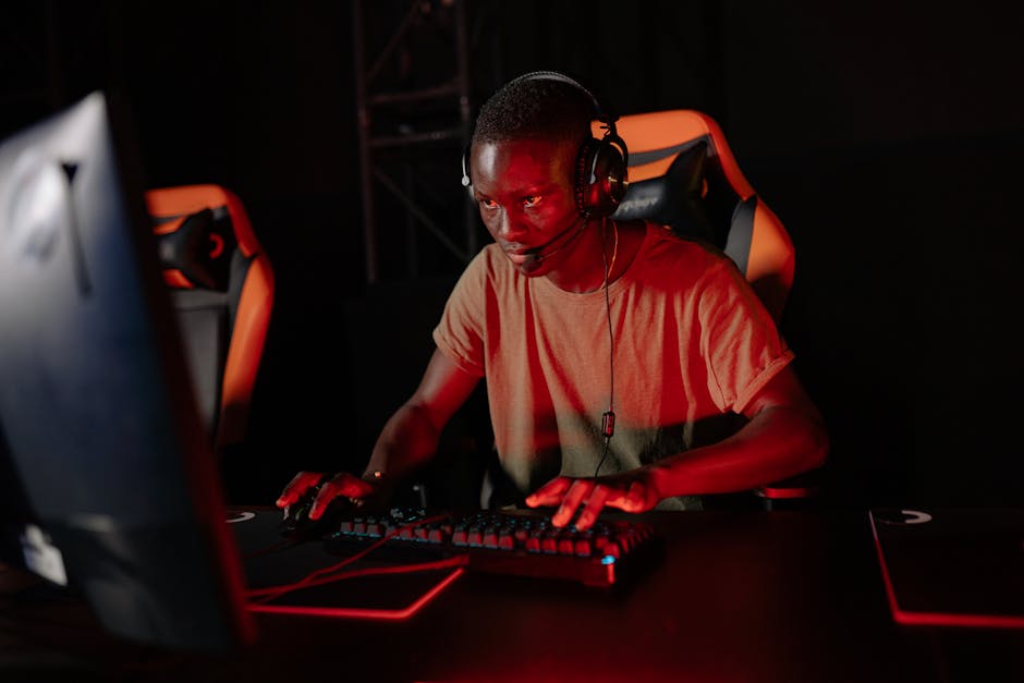 Focused gamer playing online with headset and red lighting environment.