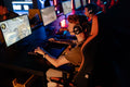 A group of gamers focused on a competitive match in a dimly lit esports arena.