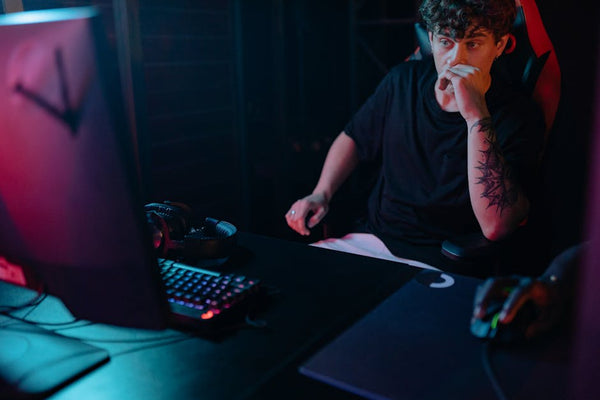 Young man intensely focused on a gaming session at night, highlighting the competitive esports atmosphere.
